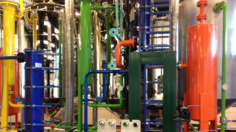 A room full of pipes of various colors and other manufacturing equipment A room full of pipes of various colors and other manufacturing equipment
