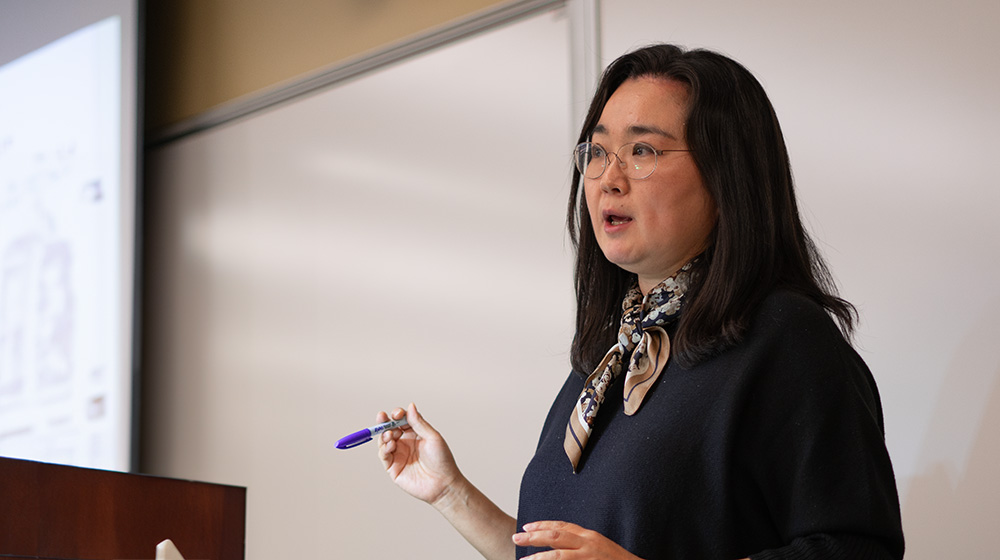 Hae Mi Choi teaching in a classroom with a whiteboard in the background Hae Mi Choi teaching in a classroom with a whiteboard in the background